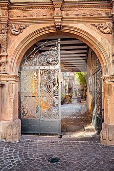 Gate on old architecture leading into a courtyard restaurant in Europe