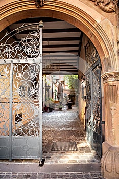 Gate on old architecture leading into a courtyard restaurant in Europe