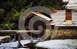 Gate of an old house with a tiled roof with a brick pipe