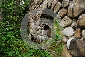 Gate or part of bridge made of big pebbels stone of granite in zoom.