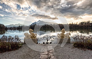 Gate with sculptures at a lake during sunset