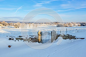 Gate at a stone wall covered with snow