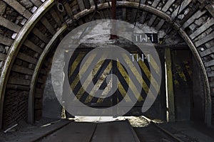 Gate in underground illuminated tunnel