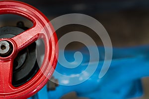 Gate valve with a red handgrip and a blue tube, close-up