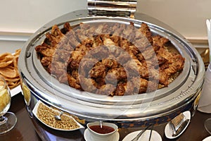 Gatering of Deep Fried Chicken with garlic and pepper in round boiled silver plate with cover, with many snack