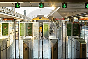 gates, gates, or turnstiles for accessing the train at the railway station with green signs.