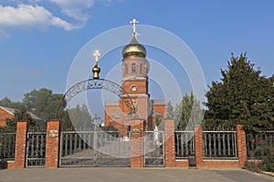 Gates to the Church of the Holy Great Martyr and Healer Panteleimon in the rays of the setting sun in the city of Slavyansk-on-