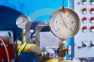 A gauge showing the gas pressure is installed on the pipeline. Industrial background.