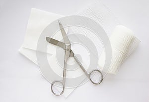 Gauzes, scissors and roll gauze on white background,closed up