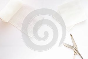 Gauzes, scissors and roll gauze on white background,top view