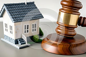 gavel closeup, striking down near a small house model real estate law