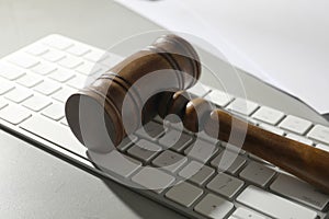 Gavel and computer keyboard on table. Cyber crime