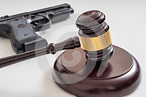 Gavel in front of a pistol. Gun laws and legislation concept photo