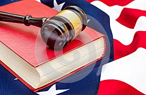 Gavel with law book on american flag. Close up