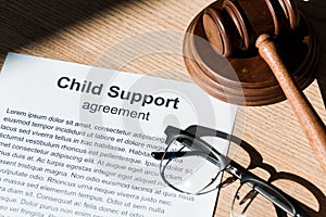 Gavel near document with child support agreement and glasses