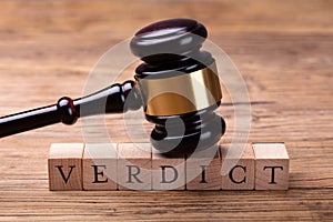 Gavel Over Wooden Blocks With Text Verdict photo