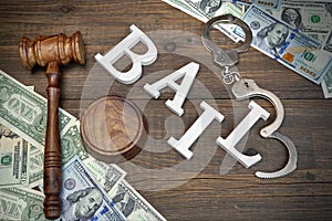 Gavel, Sign BAIL, Handcuffs And Dollar Cash On Wood Background