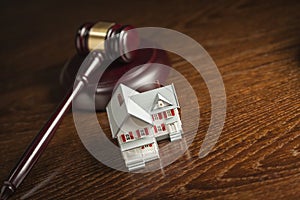 Gavel and Small Model House on Table