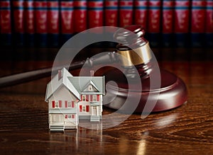 Gavel and Small Model House on Wooden Table