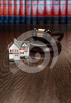 Gavel and Small Model House on Wooden Table