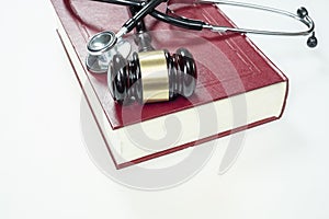 Gavel, stethoscope and book on white background