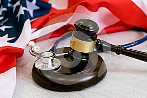 Gavel and stethoscope on national flag of USA. Forensic medicine concept.