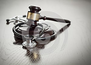 Gavel and Stethoscope on Reflective Table