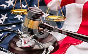 Gavel, stethoscope and scale on national flag of USA - medicine concept image