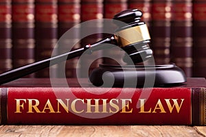 Gavel And Striking Block Over Book With Franchise Law Text