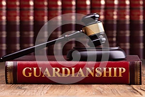 Gavel And Striking Block Over Guardianship Law Book