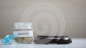 Gavel striking sound block, alimony glass jar and pacifier table, child support