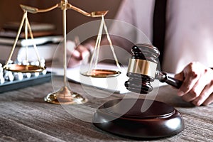 Gavel on wooden table and Lawyer or Judge working with agreement in Courtroom theme, Justice and Law concept