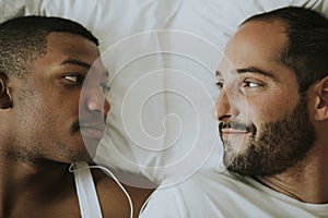 Gay couple cuddling in bed