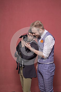 Gay couple, kissing and cuddling a puppy