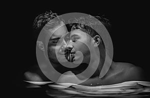 Gay couple relaxing in swimming pool. LGBT. Two young men kissing and hugging