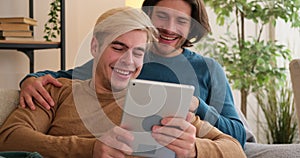 Gay couple using digital tablet at home