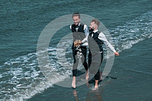 Gay couple wedding. Lgbt gay marriage couple having romantic moment together. Two gay men after wedding on a sea beach