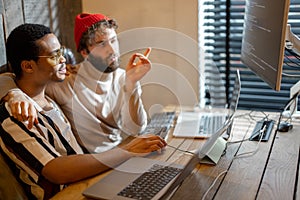 Gay couple working on computers at home office