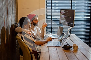 Gay couple working on computers at home office