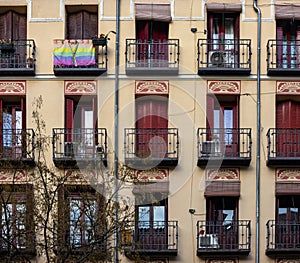 Gay flag at a balcony, facade of an apartment building in a gay friendly neighborhood Chueca, Madrid, Spain