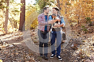 Gay Male Couple With Baby Walking Through Fall Woodland