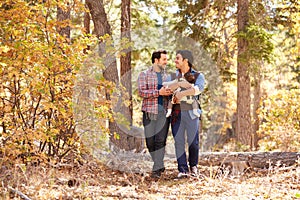 Gay Male Couple With Baby Walking Through Fall Woodland