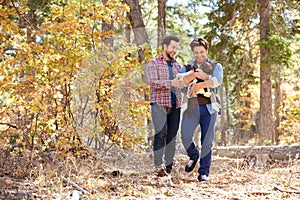 Gay Male Couple With Baby Walking Through Fall Woodland