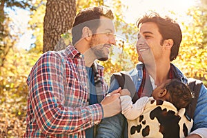 Gay Male Couple With Baby Walking Through Fall Woodland