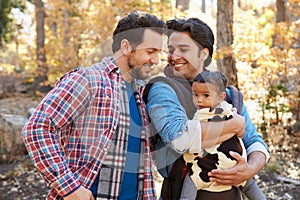 Gay Male Couple With Baby Walking Through Fall Woodland