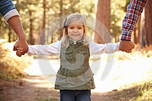 Gay Male Couple With Daughter Walking Through Fall Woodland