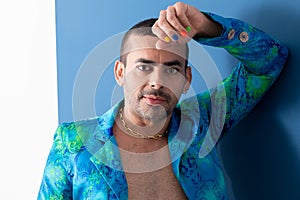 Gay man with colorful nails, rainbow colors, freedom, no prejudice, beautiful nails, blue and green clothes on a blue background photo