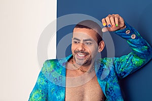 Gay man with colorful nails, rainbow colors, freedom, no prejudice, beautiful nails, blue and green clothes on a blue background. photo