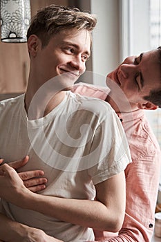 Gay man looking at the his boyfriend while spending time together at home