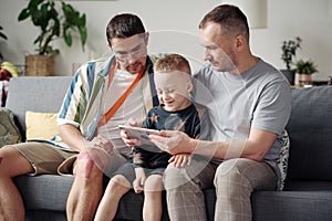 Gay parents with adopted son at home